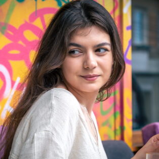 happy-young-woman-with-glass-lemonade-against-bright-painted-wall (1)